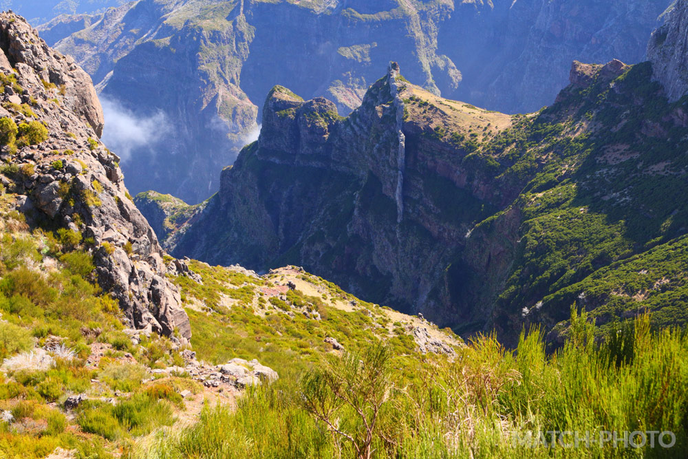 Blick in die tiefen Täler. Bergspitzen und Grasflächen.